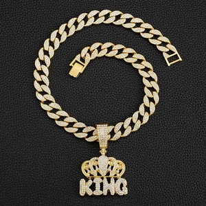 Macro detail of iced-out KING crown pendant and golden Cuban link chain texture