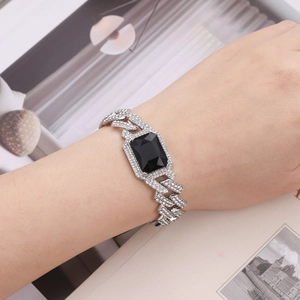 Macro shot of Cuban chain bracelet featuring a large rectangular black stone and white crystals