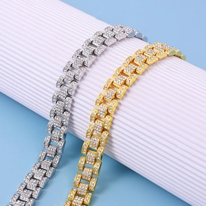 Close-up of gold and silver cuban link bracelets with sparkling cubic zirconia on a white stand