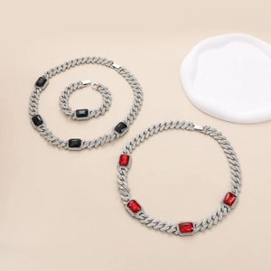 Hip hop Cuban link set with sparkling crystals and red rectangle gemstones on beige background