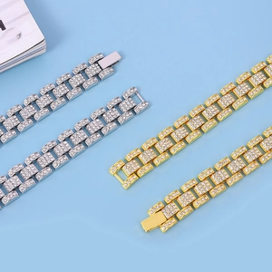 Macro detail of gold and silver iced out brick link bracelets with buckle clasp