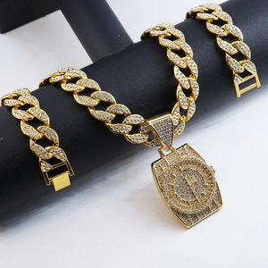 Close-up of gold plated Cuban link chain and watch pendant with white rhinestones