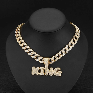 Détail du pendentif KING doré avec des strass étincelants sur une chaîne cubaine glacée