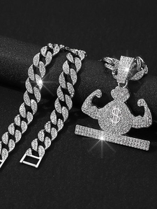 Macro shot of silver hip hop necklace with iced-out dollar money bag and muscle arm pendant