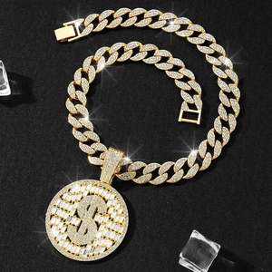 Gros plan du pendentif signe dollar avec chaîne cubaine dorée sertie de faux diamants