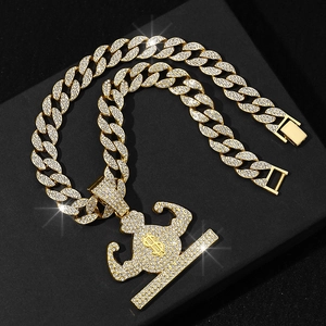 Close-up of hip hop muscle man pendant with cubic zirconia and gold Cuban link chain