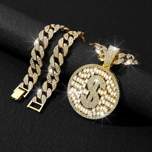 Gros plan sur la chaîne cubaine plaquée or avec grand pendentif signe dollar serti