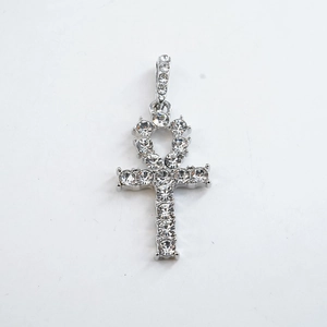 Gedetailleerde close-up van een zilveren Ankh-kruishanger bezet met fonkelende strass