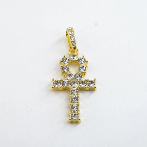 Detailopname van de gouden Ankh kruis hanger versierd met sprankelende zirkonia stenen
