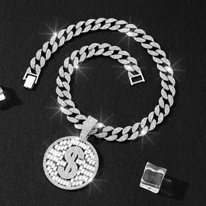Gros plan d'un pendentif dollar argenté serti de strass sur une chaîne cubaine