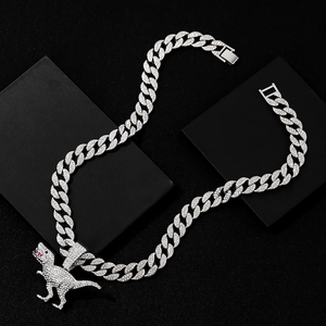 Makroaufnahme von silbernem Hip-Hop Dinosaurier Anhänger mit weißen Diamanten auf Schwarz