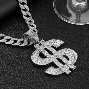 Macro detail of silver hip hop Cuban chain with sparkling iced-out dollar sign pendant