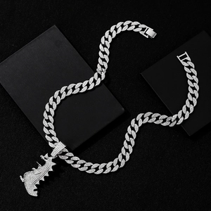 Iced out silver Cuban link chain necklace with a crystal-encrusted Tyrannosaurus Rex pendant