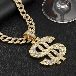 Close-up of hip hop gold Cuban chain necklace with iced out dollar sign pendant
