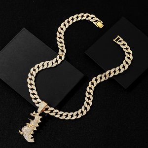 Close-up of hip-hop gold plated Cuban chain with iced out T-Rex dinosaur pendant
