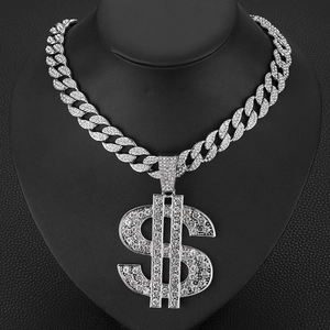 Close-up of hip hop silver iced out dollar sign pendant on a chunky cuban link chain