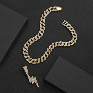 Close-up of gold hip hop Cuban chain and iced out lightning bolt pendant with crystals