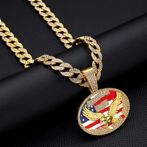 Gros plan d'une chaîne cubaine dorée avec pendentif aigle drapeau américain et cristaux blancs