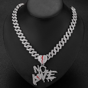 Détail du pendentif No Love cœur brisé sur une chaîne cubaine argentée sertie de zircons