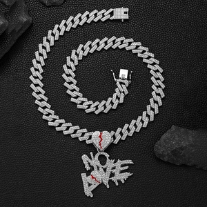 Détail du pendentif No Love avec cœur brisé rouge sur une chaîne cubaine glacée
