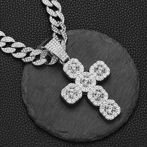 Détail macro d'un collier chaîne cubaine argentée avec un grand pendentif croix en strass