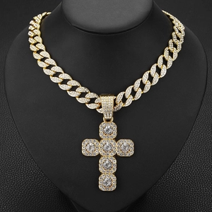 Gros plan d'une chaîne cubaine hip-hop dorée avec pendentif croix serti de diamants