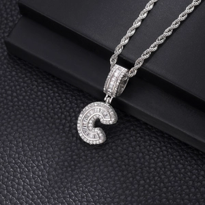 Détail macro du pendentif lettre C en argent serti de diamants baguette sur chaîne torsadée