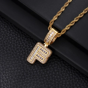 Close-up of hip hop gold letter F pendant with pave zircons and heavy rope chain