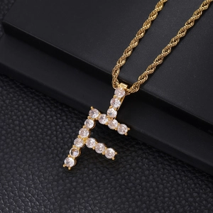 Macro shot of gold-plated iced-out letter F pendant with rope chain on black display box