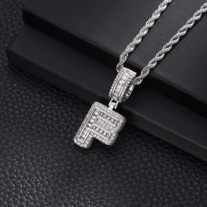 Vue macro du pendentif Hip-hop lettre F argentée avec zircons sertis et chaîne torsadée