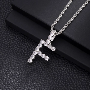 Macro shot of silver hip hop pendant letter F with cubic zirconia and rope chain