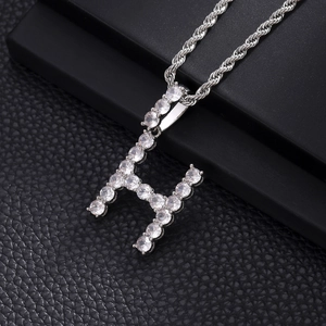 Detail of silver letter H pendant with shimmering cubic zirconia on a rope chain