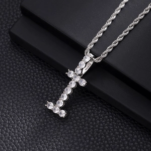 Detail view of silver cross pendant with claw-set cubic zirconia on a rope chain