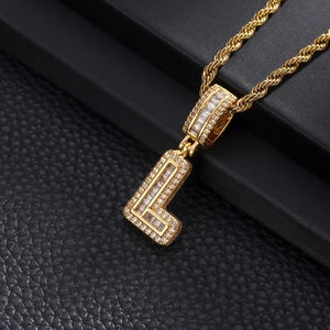 Detailed close-up of iced out gold letter L pendant with cubic zirconia on rope chain