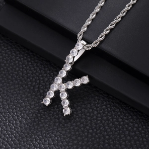 Macro detail of silver-tone letter K pendant with cubic zirconia and rope chain