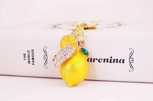 Macro shot of yellow lemon keychain with sparkling rhinestones and a green crystal