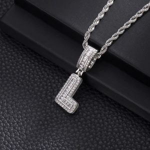 Vue macro du pendentif lettre L en argent serti de zircons et sa chaîne torsadée