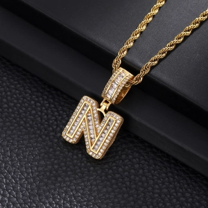Macro shot of hip-hop letter N pendant with pavé cubic zirconia and gold rope chain