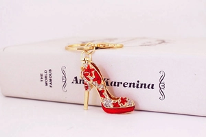 Détail d'un porte-clés escarpin rouge avec strass et motif étoile sur un livre