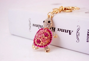 Close-up of pink crystal turtle keychain with gold plating and sparkling rhinestones