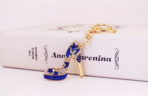 Détail du porte-clés talon haut en strass avec étoile bleue et fermoir doré sur un livre