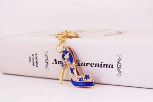 Détail d'un porte-clés talon haut en émail bleu avec strass sur un livre ancien
