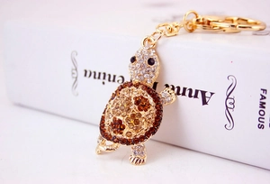Macro view of crystal encrusted golden sea turtle keychain with detailed sparkling rhinestones