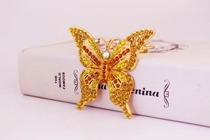 Gros plan d'un porte-clés papillon doré avec strass ambrés sur un livre ancien