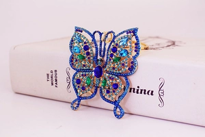 Détail du porte-clés papillon avec strass bleus et verts sur base en alliage doré