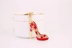 Détail de porte-clés escarpin rouge avec strass blancs sur une tasse de café