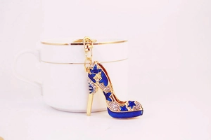 Détail de porte-clés escarpin bleu à strass avec motif d'étoiles dorées ajouré