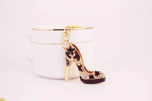 Détail d'un porte-clés escarpin avec étoiles en émail noir et strass sur une tasse