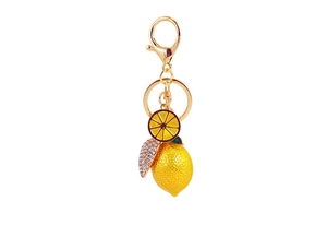 Close-up of lemon keychain with rhinestone leaf and yellow enamel fruit slice