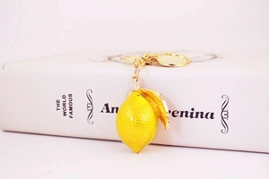 Detail of yellow lemon keychain with rhinestone accents and gold metal snap hook